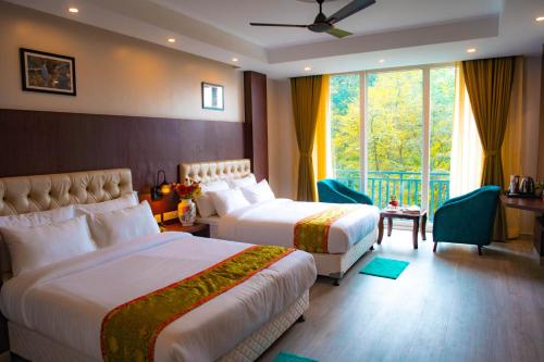 Bhurtuk的住宿－Avianna Gangtok Resort & Spa，酒店客房设有两张床和窗户。