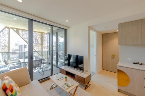a living room with a couch and a tv at Realm Apartments by CLLIX in Adelaide