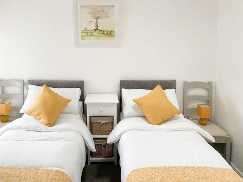 two beds sitting next to each other in a room at The White Cottage in Gargrave