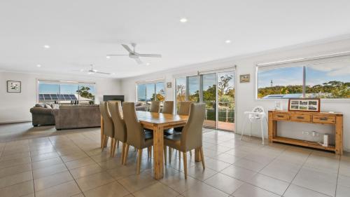 a dining room with a table and chairs at Pelican House - Modern Family Retreat in Lakes Entrance