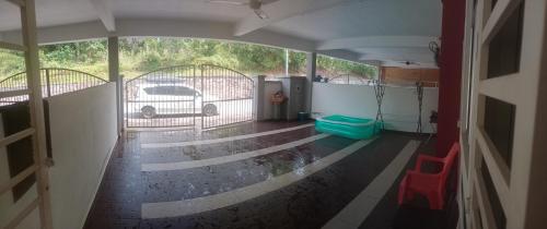 een uitzicht op een garage met een auto door een poort bij FENDIONYA CORAL in Port Dickson
