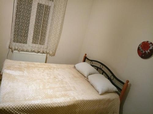 a bedroom with a bed with two pillows on it at AZAT НОМЕ in Tbilisi City