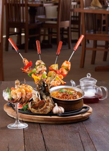 a plate of food on a wooden table with food at Desert Nights Resort in Shāhiq