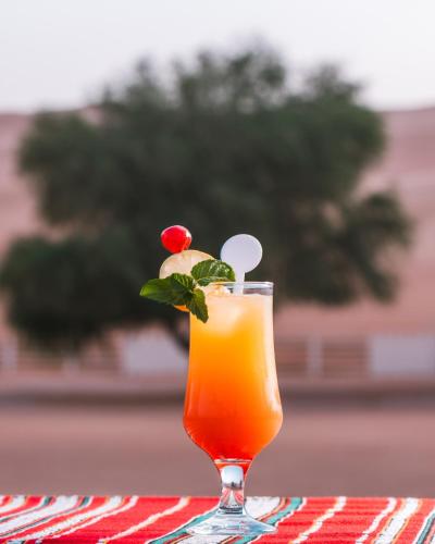 a drink in a glass sitting on a table at Desert Nights Resort in Shāhiq