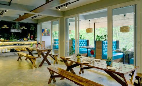 uma sala de jantar com mesas de madeira e cadeiras azuis em Avianna Gangtok Resort & Spa em Bhurtuk