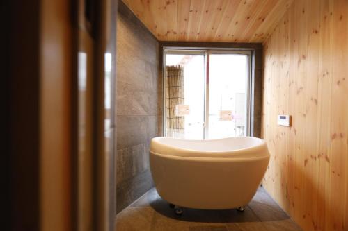 a bath tub in a bathroom with a window at 星のワルツ　御家堂(Oiedo) in Komoro