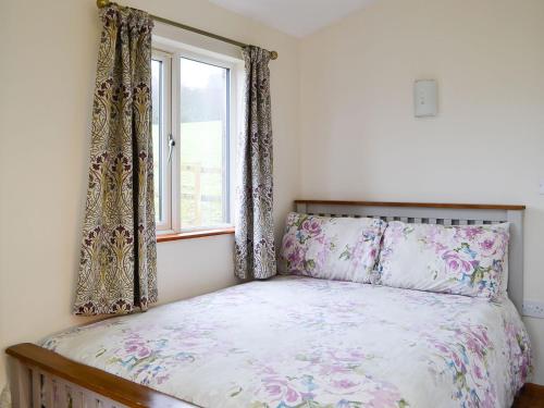 a bedroom with a bed and a window with curtains at Ty Nant - Uk32239 in Lower Chapel