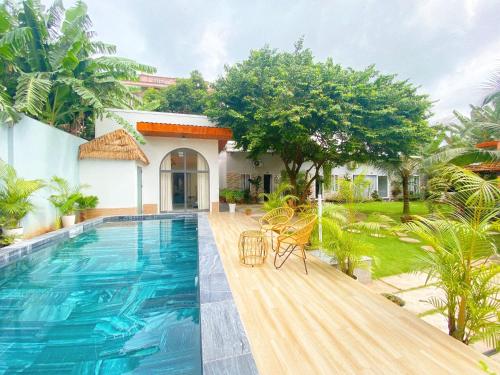 a villa with a swimming pool and a house at Hồ Cốc Homestay in Ho Coc