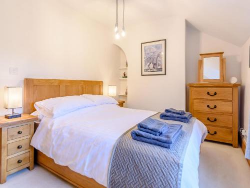 a bedroom with a bed with two blue towels on it at Lambton Cottage in Grosmont