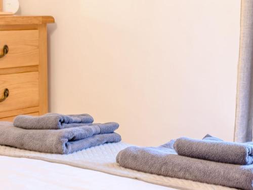 a pile of towels sitting on top of a bed at Lambton Cottage in Grosmont