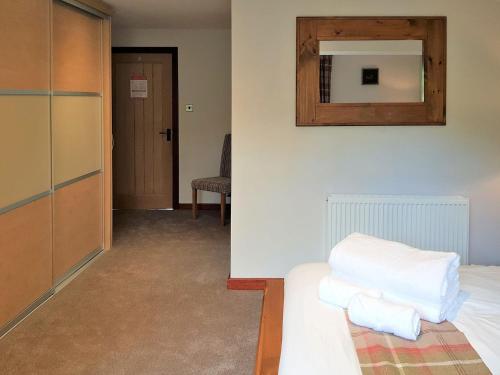 a room with a bed and a mirror on the wall at Trebor Cottage in Annan