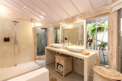 a bathroom with two sinks and a shower at Villa Little Mannao in Kerobokan