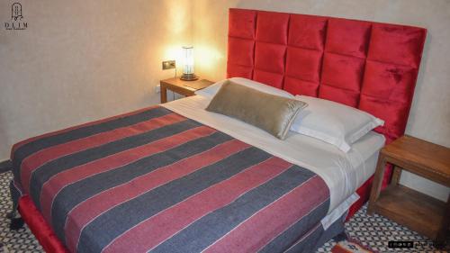 a bedroom with a large bed with a red headboard at Auberge RIAD DLIM Tamraght in Tamraght Ouzdar