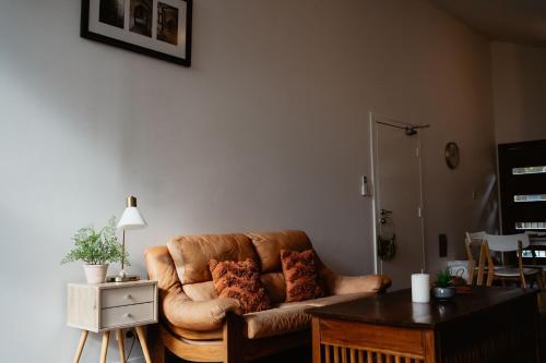 a living room with a brown couch and a table at Premalaya in Yallingup