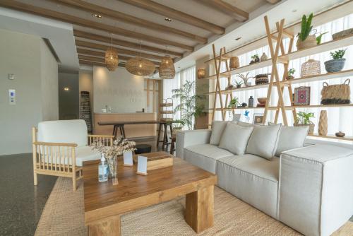 a living room with a couch and a table at Tribe Pattaya in Jomtien Beach