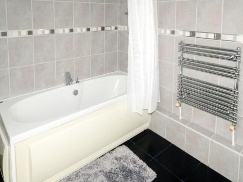 a bathroom with a bath tub with a shower curtain at Longmead in Berry Pomeroy