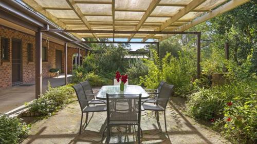 un patio con mesa y sillas bajo una pérgola en Shady Trees Barrington, en Barrington