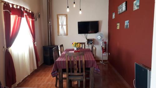 comedor con mesa, sillas y TV en La Comarca en Uspallata
