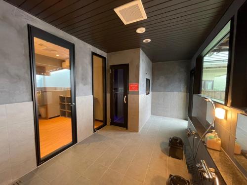 a bathroom with a hallway with a door and a mirror at Shoji Lake Hotel in Fujikawaguchiko
