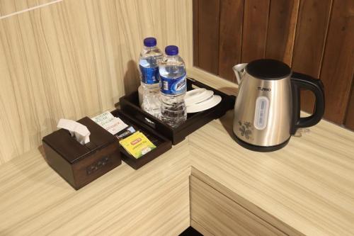 a coffee maker and water bottles on a counter at d' Omah Afi 1 in Jarakan