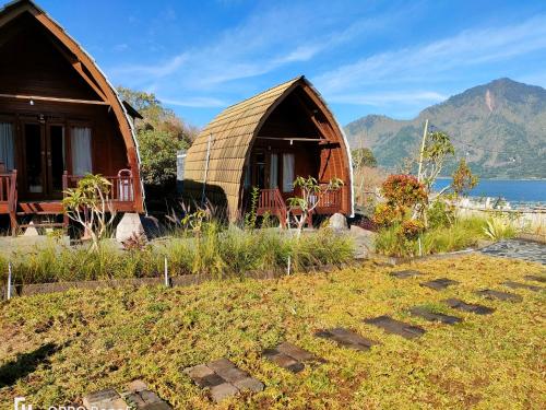 a couple of yurt homes on a hill next to the water at Batur Water Park Villa in Bangli