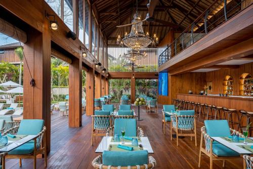 a dining room with blue chairs and tables at Kappa Senses Ubud in Ubud