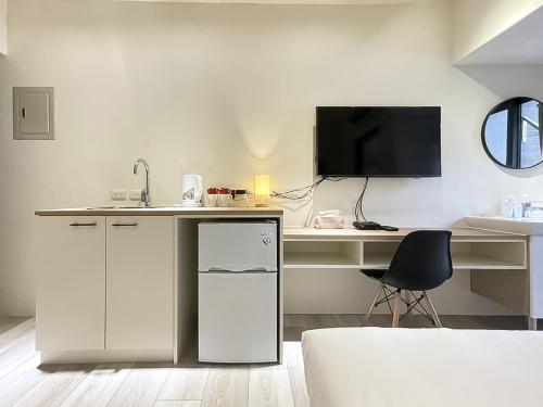 a kitchen with a counter and a desk with a chair at 旅行家 Affetto Hostel in Taichung