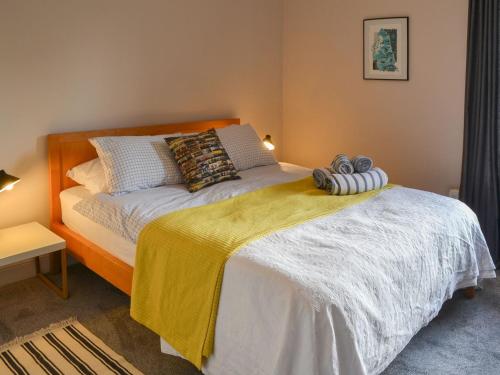 a bedroom with a bed with a yellow blanket on it at White Feathers in Alnwick