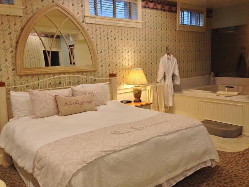 a bedroom with a large bed and a bath tub at Chambery Inn in Lee