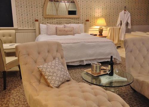 a bedroom with a bed and a couch and a table at Chambery Inn in Lee