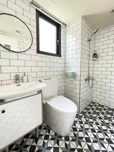 a bathroom with a toilet and a sink and a mirror at 旅行家 Affetto Hostel in Taichung