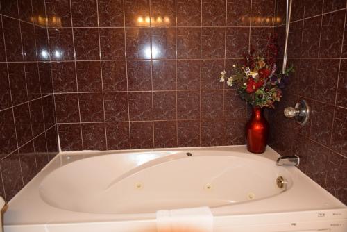 a bath tub with a vase with flowers in it at Auberge Wild Rose Inn in Moncton