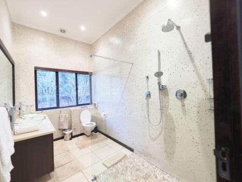 a bathroom with a shower and a sink and a toilet at 4 Bedroom Holiday Home, Bayhill, Whiteriver Country Estate in White River