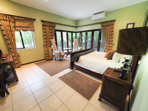 a bedroom with a bed and a table with a lamp at 4 Bedroom Holiday Home, Bayhill, Whiteriver Country Estate in White River