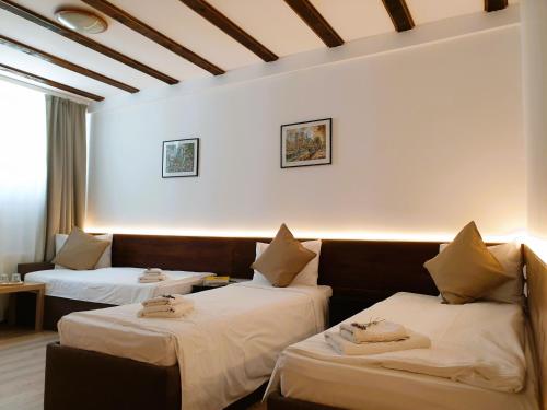 Habitación de hotel con 2 camas y sofá en Confort INN, en Otopeni