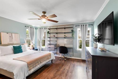 a bedroom with a bed with a ceiling fan and a desk at Stunning Pool and Chefs Kitchen NRG MedCenter in Houston