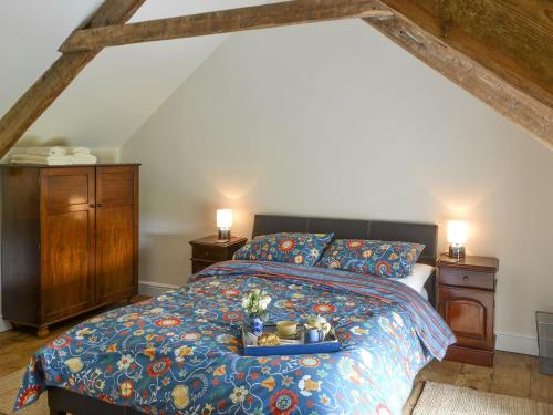 a bedroom with a bed with a tray of food on it at Greenyard Cottage in Rothbury
