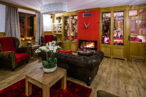 a living room with a couch and a fireplace at Wellness hotel V Nebi in Kořenov