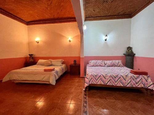 a bedroom with two beds in a room at Olivos Habitación cuádruple in Tequisquiapan