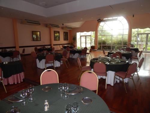 a dining room with tables and chairs with wine glasses at Quintana Hotel in San Luis