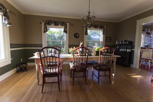 a dining room with a table and four chairs at The White House Bed and Breakfast in Medford