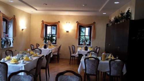 a dining room with tables and chairs with white table cloth at Der Heidkrug in Verden