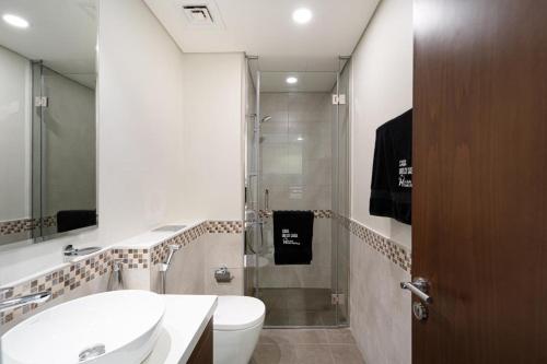 a bathroom with a shower and a toilet and a sink at Alluring 1 BD Apartment in Business Bay with Burj Khalifa view in Dubai