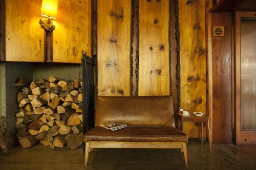 a chair in a room with a pile of wood at Hotel Antumalal in Pucón