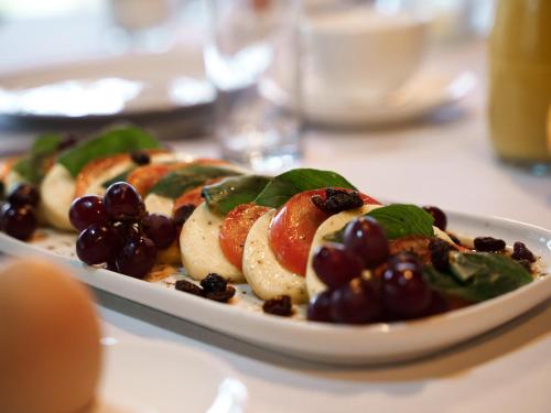 a plate of food with grapes and fruit on a table at Kruger Eden Lodge in Marloth Park