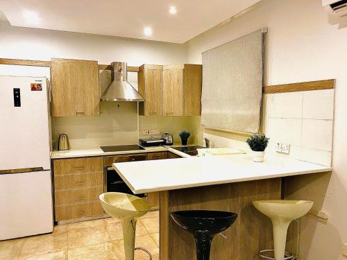 una cucina con armadi in legno e frigorifero bianco di GRACE HOUSE a Pyla