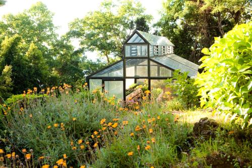 a glass house in the middle of a field of flowers at Hotel Antumalal in Pucón