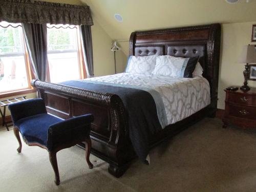 a bedroom with a large bed and a chair at Mansion Inn Lake Stevens in Lake Stevens