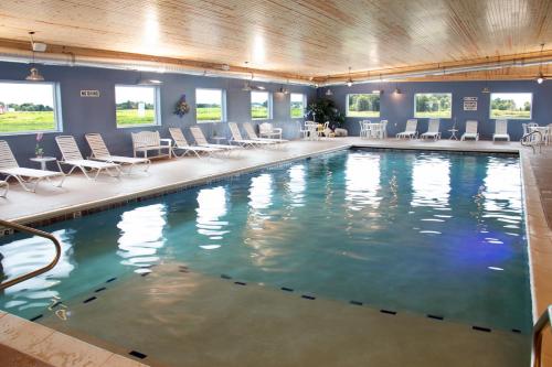 a large swimming pool with chairs and tables and chairs at Blue Gate Garden Inn in Shipshewana