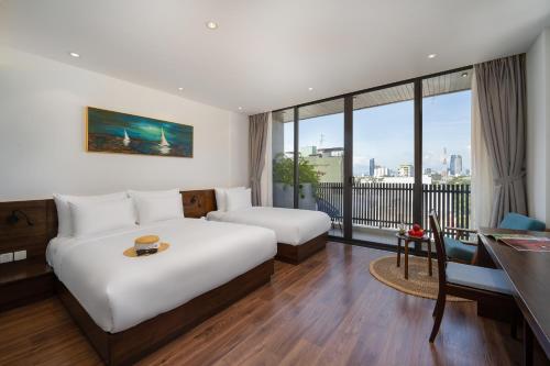 a hotel room with a large bed and a desk and a desk at Duke Casa Apartment in Danang
